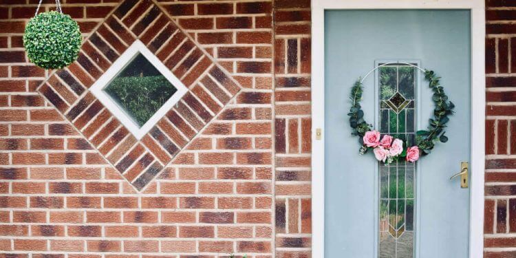 Аранжирана с цветя бяла входна врата