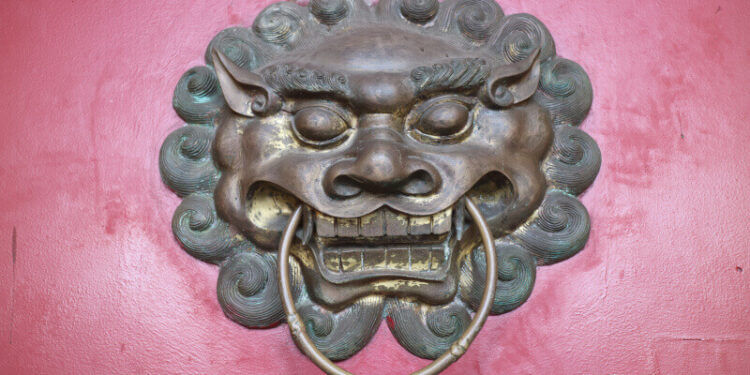 Лъвска глава под формата на чукче върху червена врата